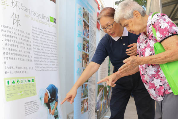 Volunteer Ng Suan Ee shows resident Wu Ya Rong (right) around the recycling point. Photo by Huang Si Ni