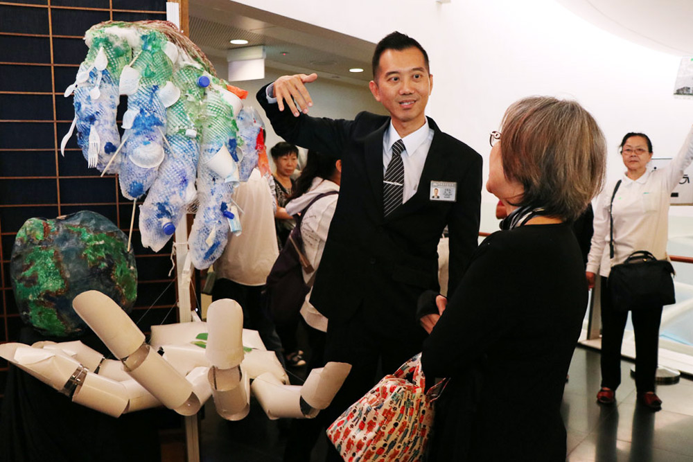 Volunteer Lee Kui Mian explaining the symbolic meanings behind the creative exhibits while advocating the importance of environmental protection (Photo by Mulias Lian)    