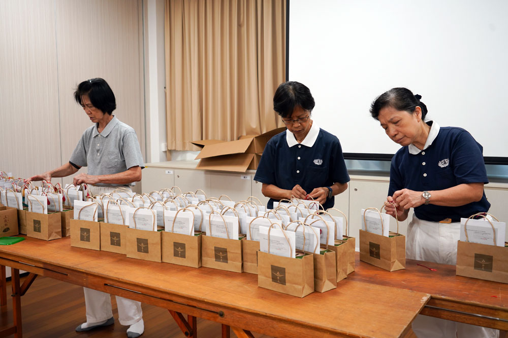 Volunteers carefully pack the three different categories of gift packs. (Photo by Chan May Ching)