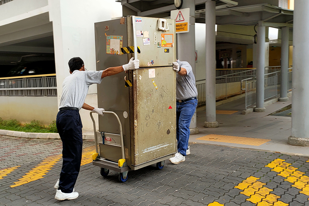 大件物品由男众志工搬运到楼下集中区，再让市镇理事会员工运走。（摄 / 林翠莲）